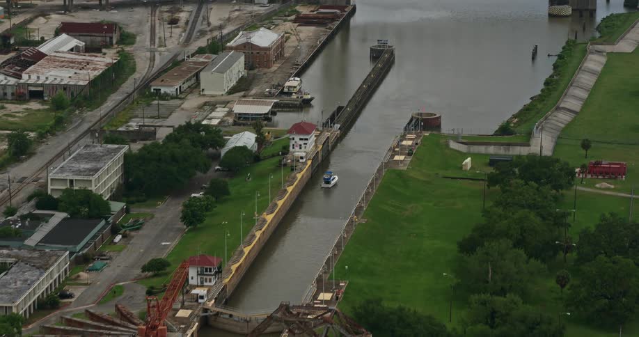 Approaching and flying over the Claiborne Avenue Bridge in New Orleans Louisiana with ships and barges in transit below on a partly cloudy day