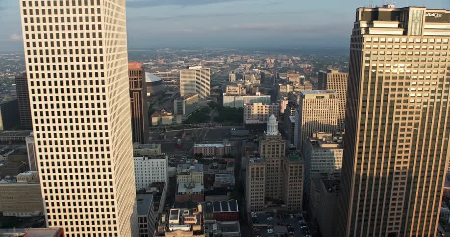 Fly over Downtown New Orleans at sunrise approaching the Superdome and City Hall capturing the beauty of Louisianas high rise buildings and government structures from a birds-eye view