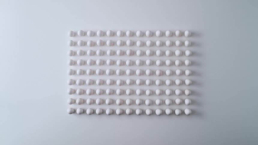 White circular shapes in the form of a rectangle on a white wall