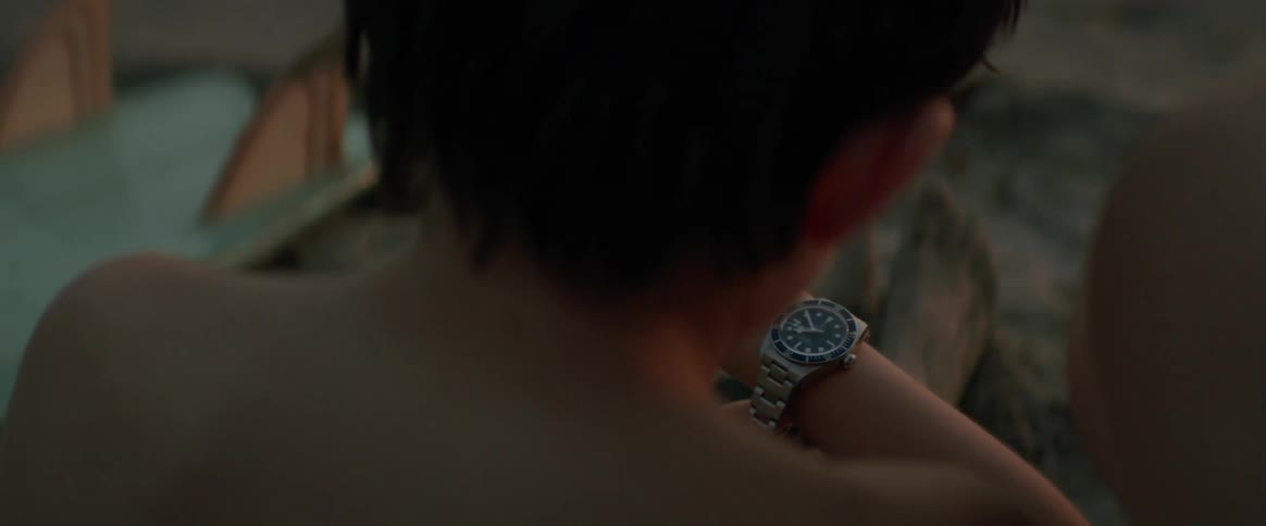Son wearing fathers silver watch sitting on the beach at sunset