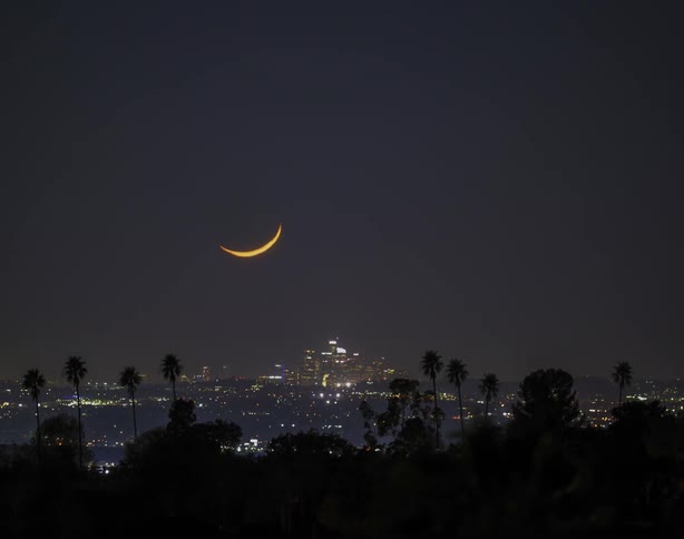 Time lapse view of the moon above a downtown city