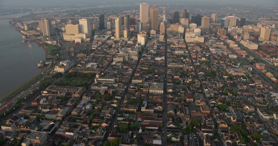 A breathtaking 4K aerial footage showcasing the tilt up from French Quarter streets to an approach of Downtown New Orleans during a spectacular sunrise revealing towering high-rises and a bustling city