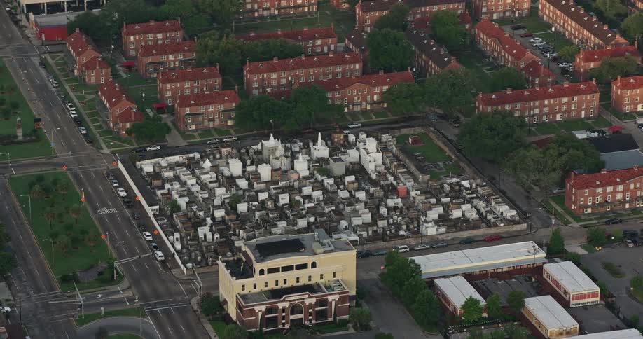 A breathtaking 4K aerial orbit of St Louis Cemetery at sunrise capturing mornings spiritual essence cloudy skies and the theological significance of the funerary ground in the French Quarter New Orleans Louisiana
