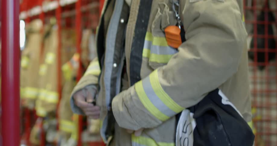 A fireman zips his jacket up
