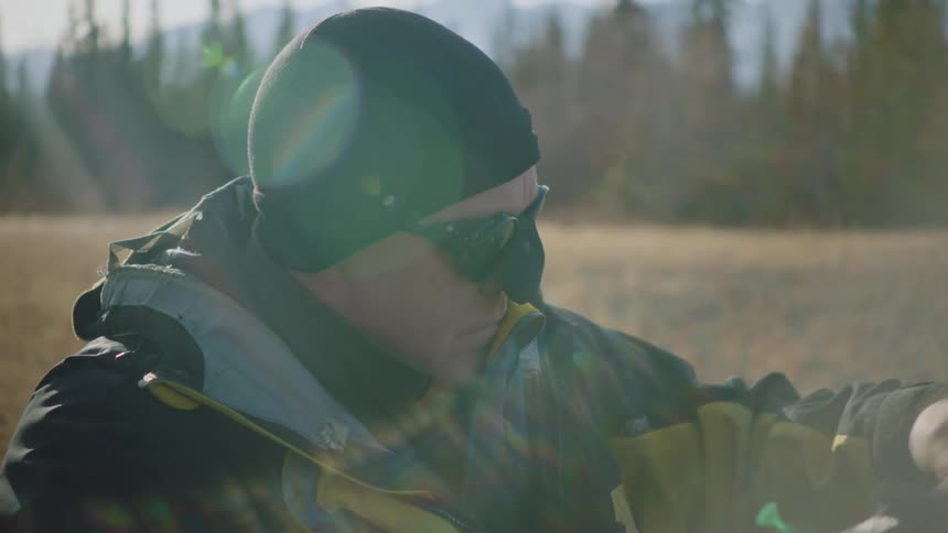 Man wearing goggles and nose cover prepares to hike on the mountains at morning