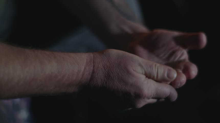 Close up view of a man touching his hands