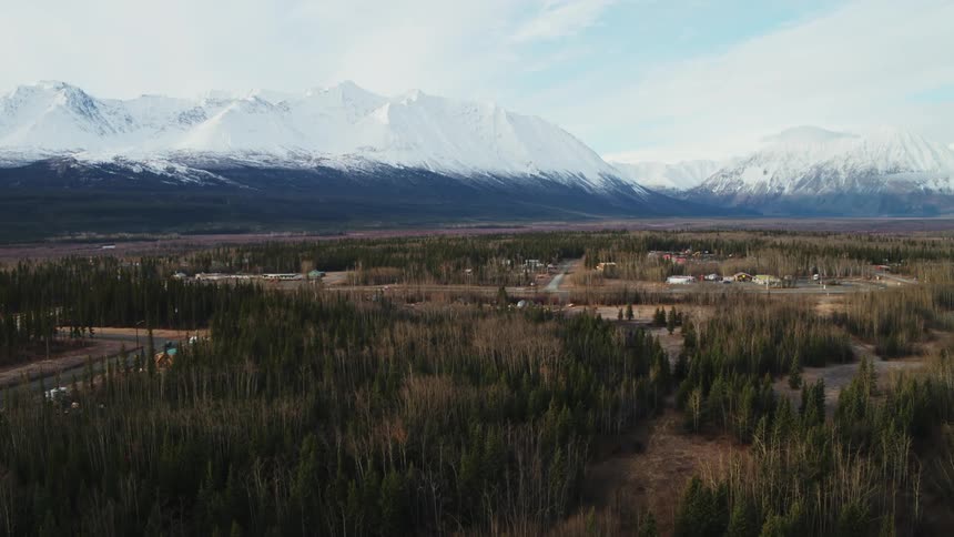 Aerial view of village and snow capped mountain range