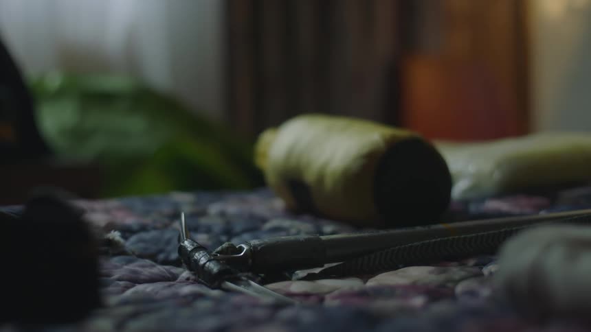 Man packing for travel throws a climbing pickaxe over the bed
