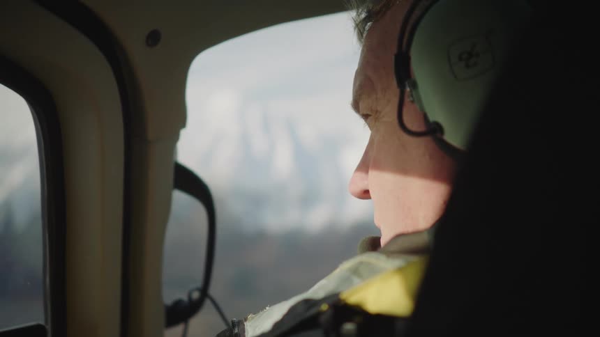 Pilot with headset and coat flies helicopter