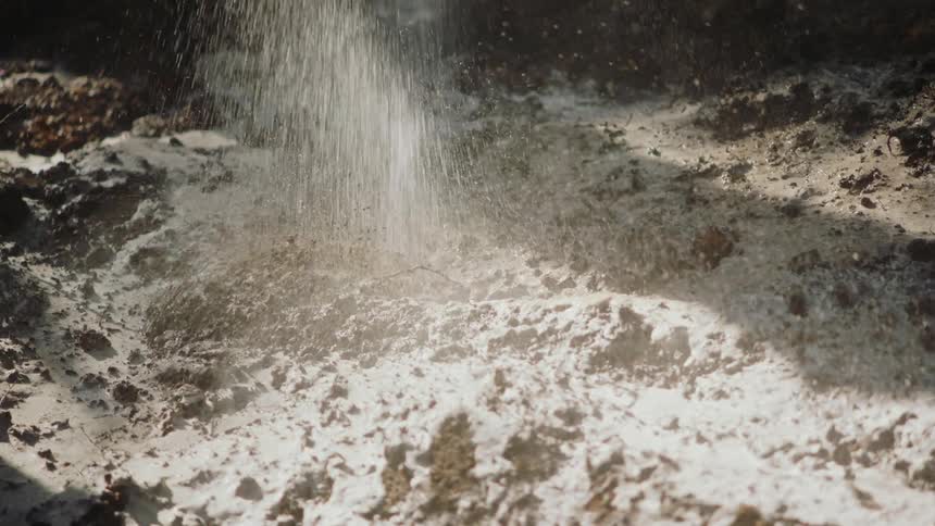 Soil on the ground being sprayed with water creating a muddy area
