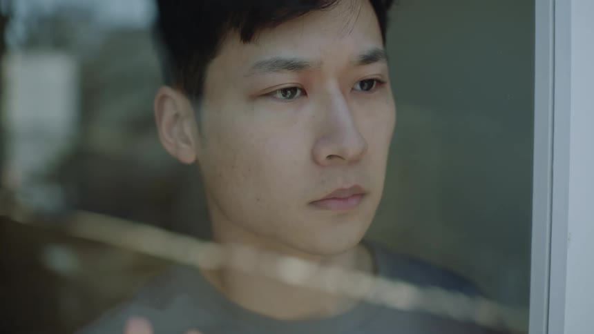 Depressed man looks out the window