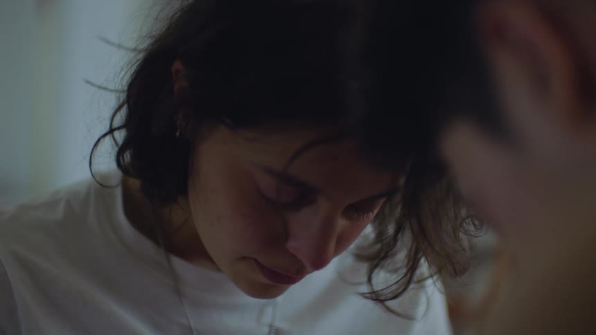 A close up of a man and woman talking as the woman puts her head down