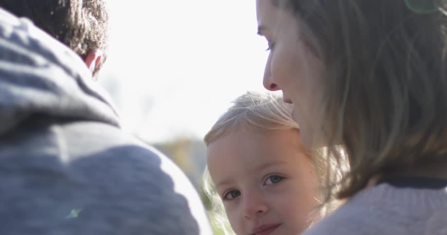 A couple and their child sitting on a bench