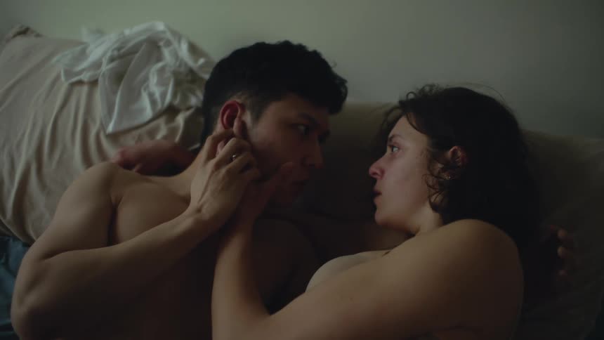 A man and woman make out in bed