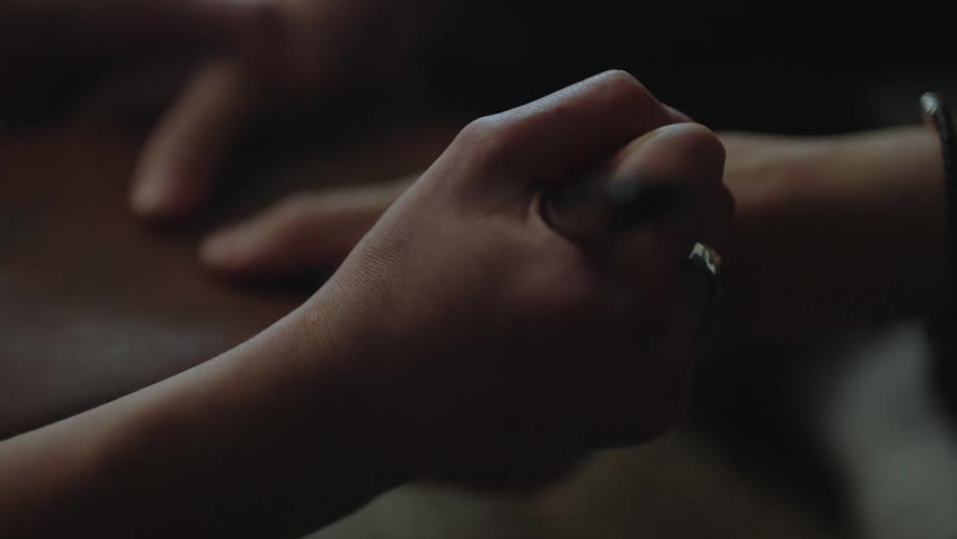 A person writes im right here with a pen on another persons hand
