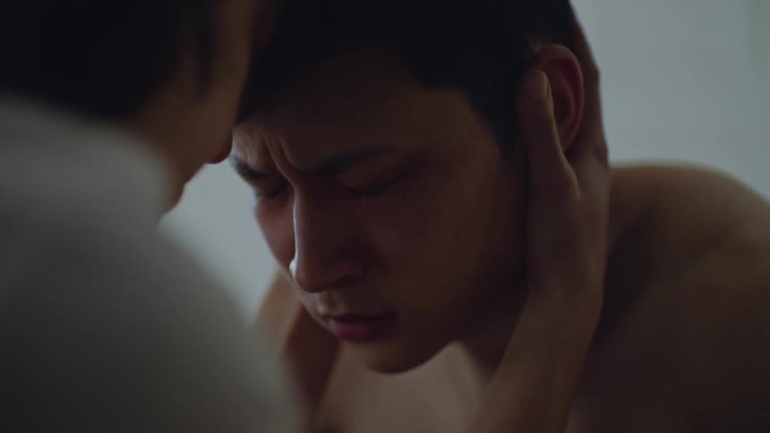 A woman kisses the forehead of a sad man