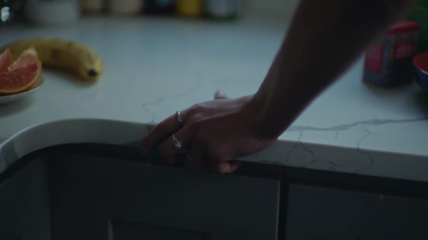 Anxious female gripping edge of kitchen countertop