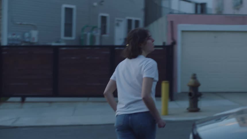 A woman running out of her house frantically then out in to the street looking around in every direction before seeing a man in the street