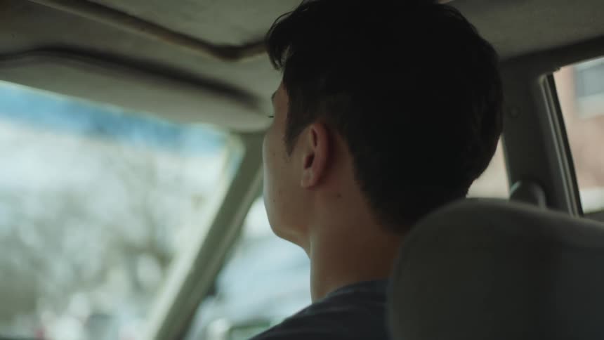 A man rides in the front passenger seat of a vehicle