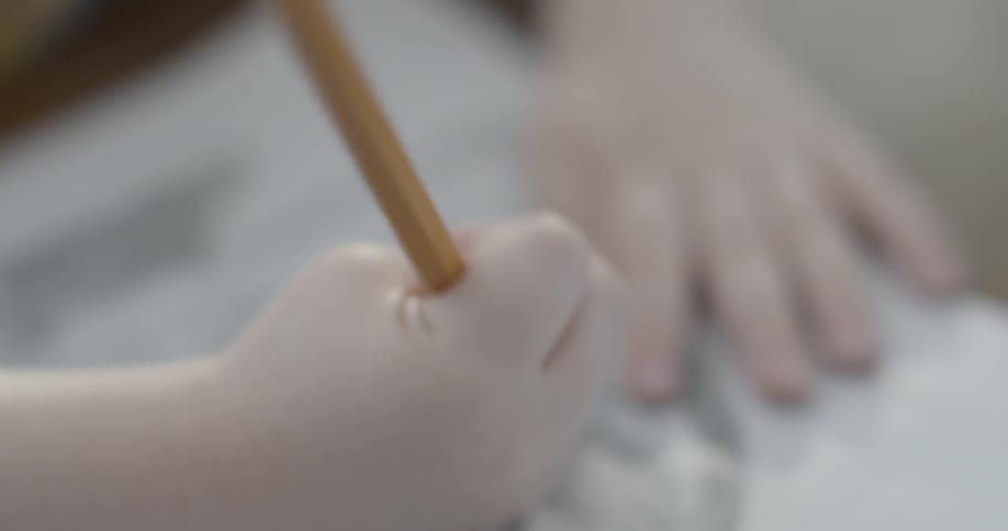 A child is drawing with a pencil