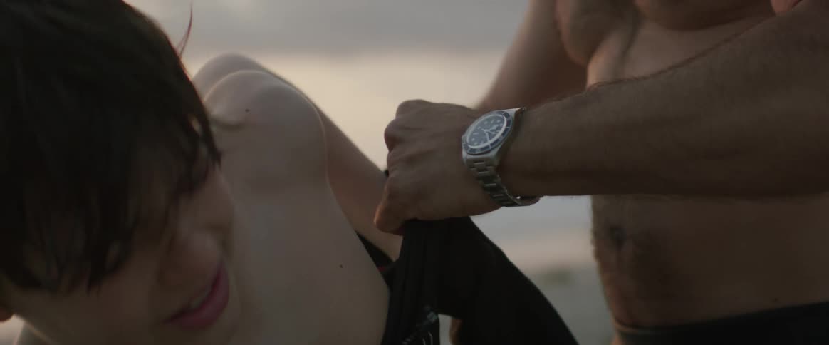 A father helps his son put on a wet suit