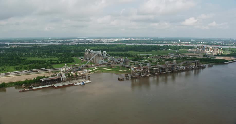 Aerial footage of an industrial factory on a riverfront in New Orleans Louisiana during daytime