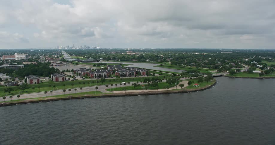 A 4K aerial shot orbiting around apartment buildings and suburbs by a canal near the shore of Lake Pontchartrain in Gentilly Louisiana