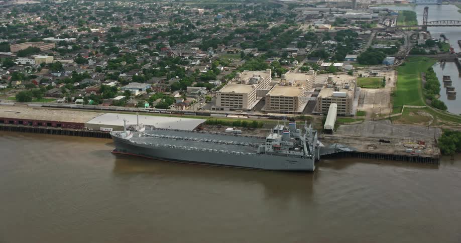 Aerial footage of two Naval Reserve warships docked on the Mississippi River in Bywater New Orleans during the summer