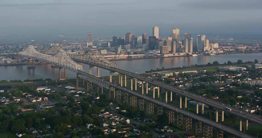 Stunning 4K aerial footage at sunrise of the Crescent City Connection Bridge and Downtown New Orleans Louisiana overlooking the Mississippi River and city skyline