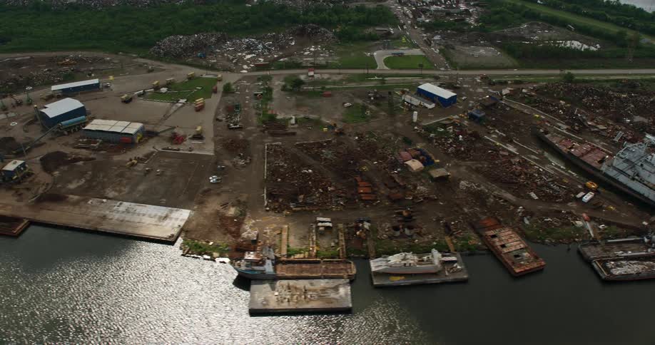 An aerial view of urban residential and industrial areas revealing an industrial canal in Lower Ninth Ward with a shipyard and ships docked