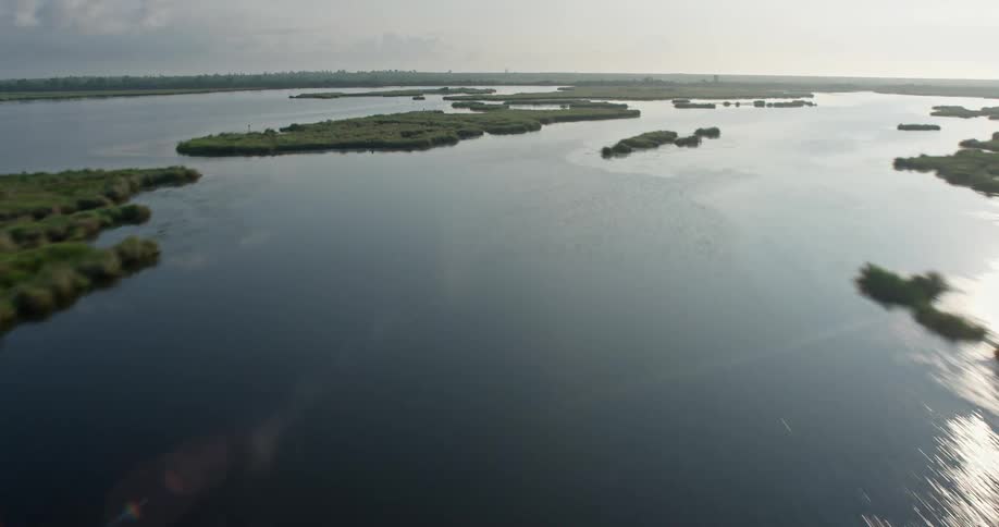 Flying low over marshland and bayou this 4K aerial footage captures the sunrise and reveals the surge barrier in St Bernard Parish Louisiana