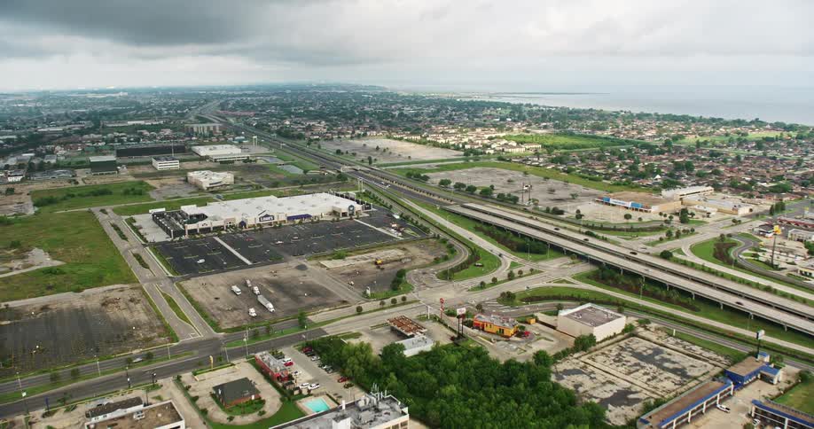 Aerial view of a Lowes store in New Orleans East with office buildings in the background and light traffic on the nearby highways during sunrise on a cloudy day