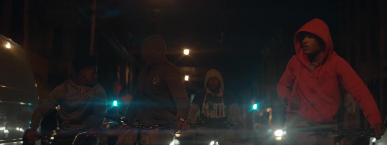 A group of young men riding their bikes at night