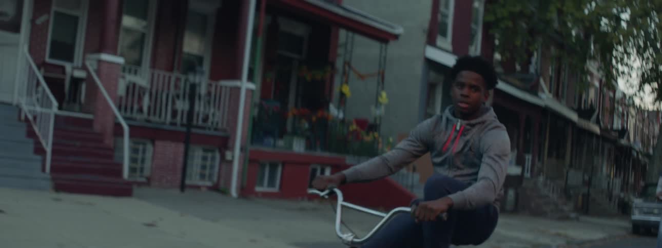 A man in a hoodie rides a bike