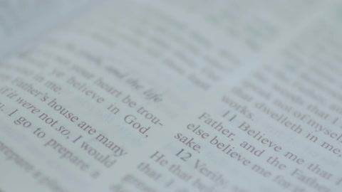 A person's finger moves down the book page