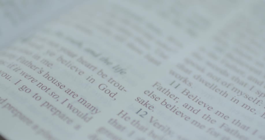A person's finger moves down the book page