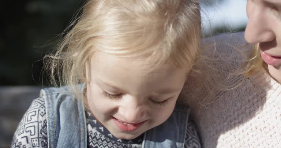 A woman is smiling with a child next to her