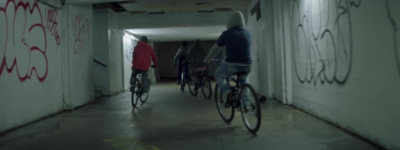 A group of people ride their bikes down a hall