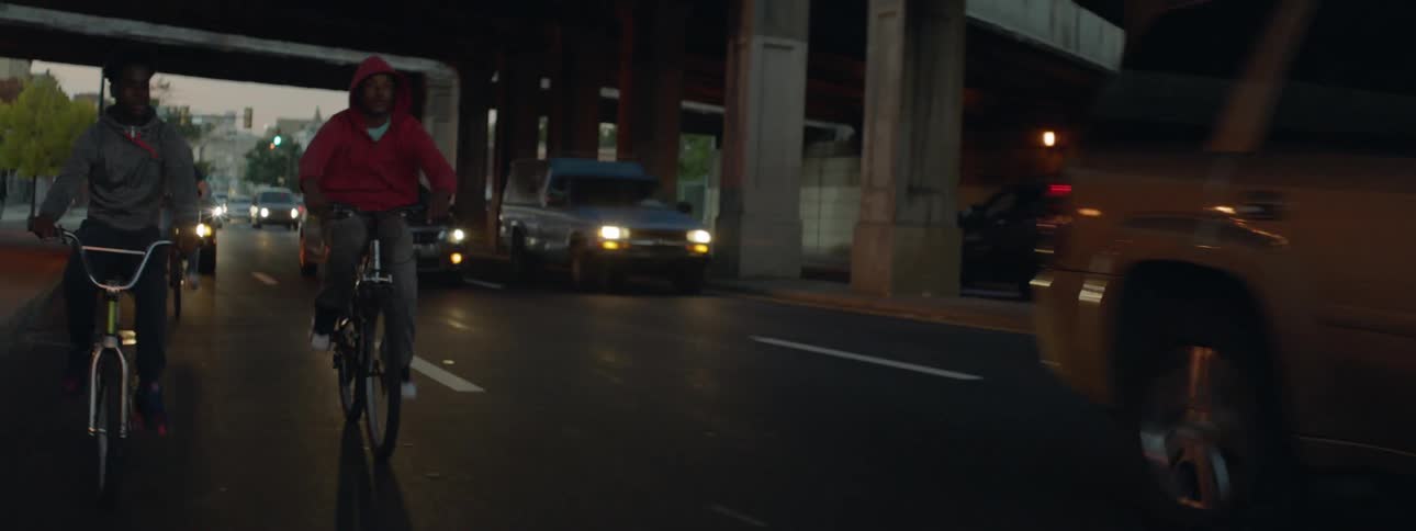 People ride their bikes right on the side of moving cars in traffic