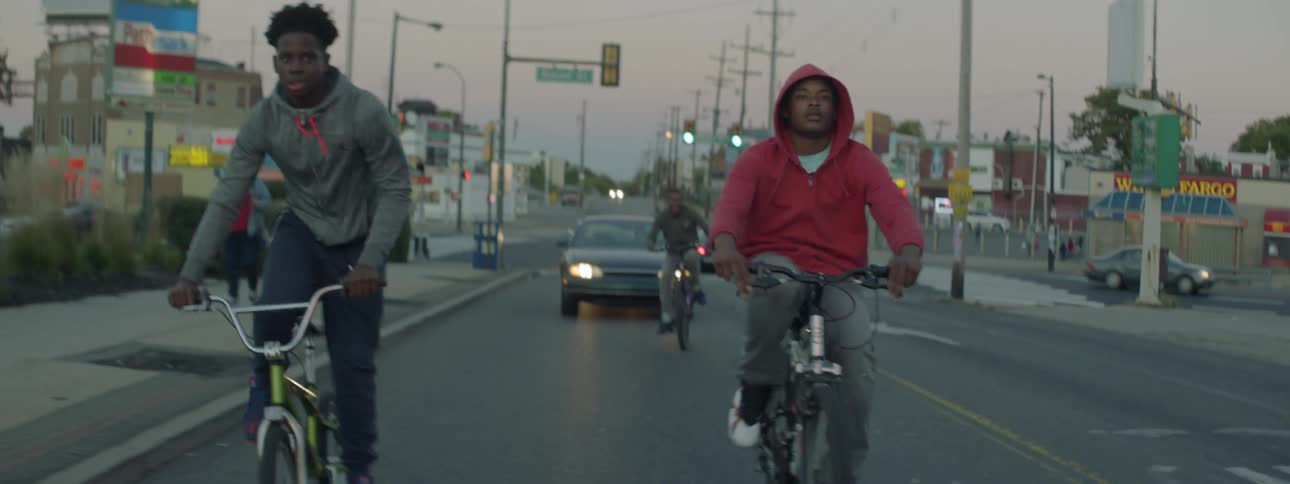 A group of young men riding down the street