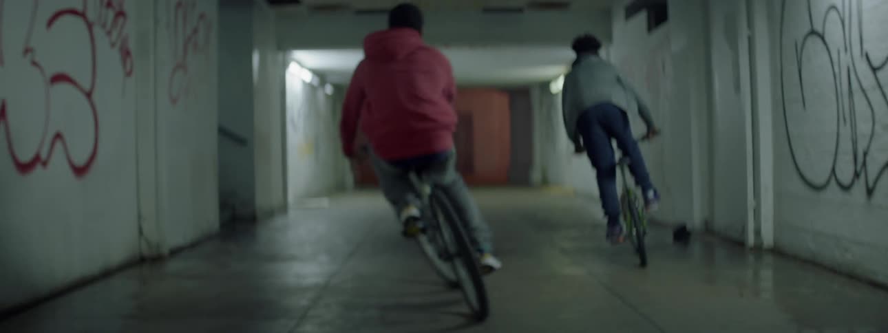 Bikes race down a long dark hall