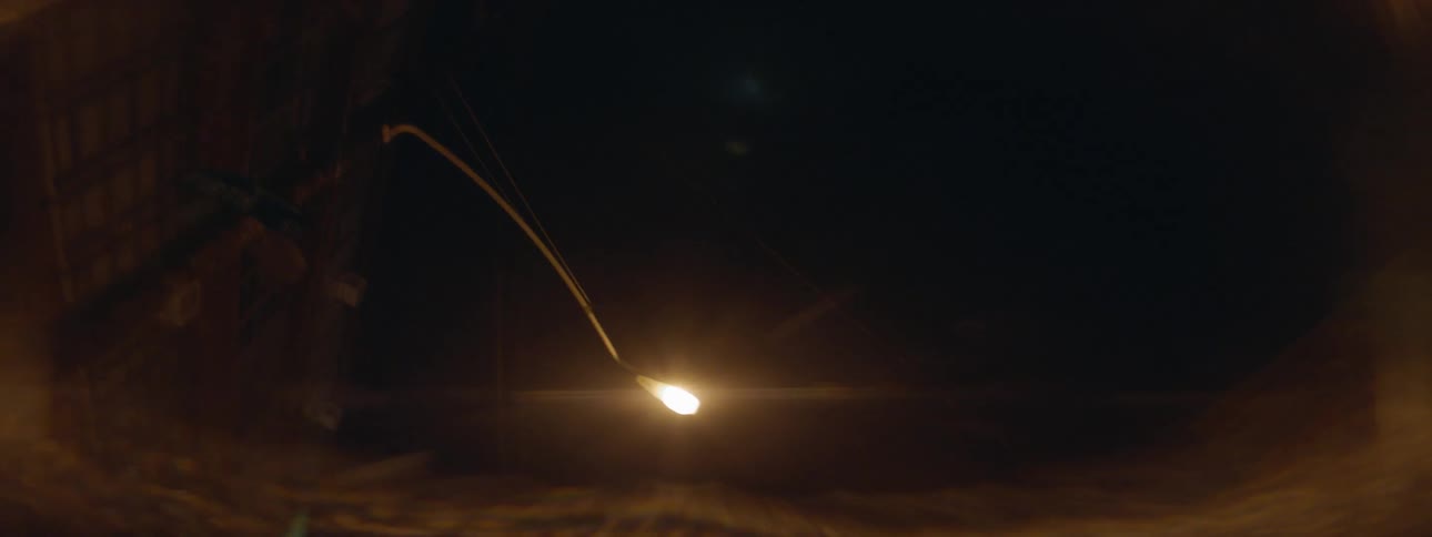 Small light on the end of a wand going through darkness