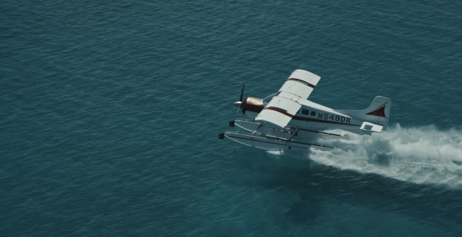 Seaplane moves across surface of the ocean leaving a wake