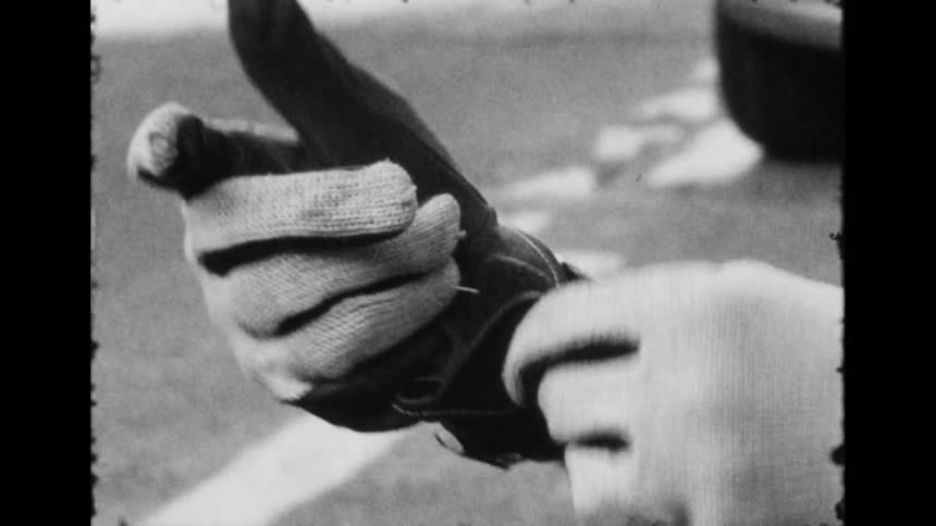 A close up of a man putting gloves on and getting on a bike on the street