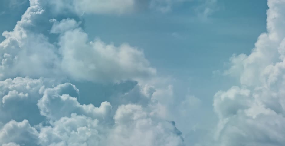 Cumulus clouds move across the sky on a beautiful day