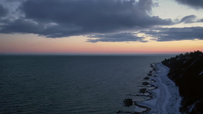 The sun is setting in the horizon of the ocean