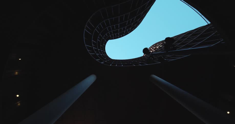 Curved opening in architecturally detailed structure allows glimpse of blue sky