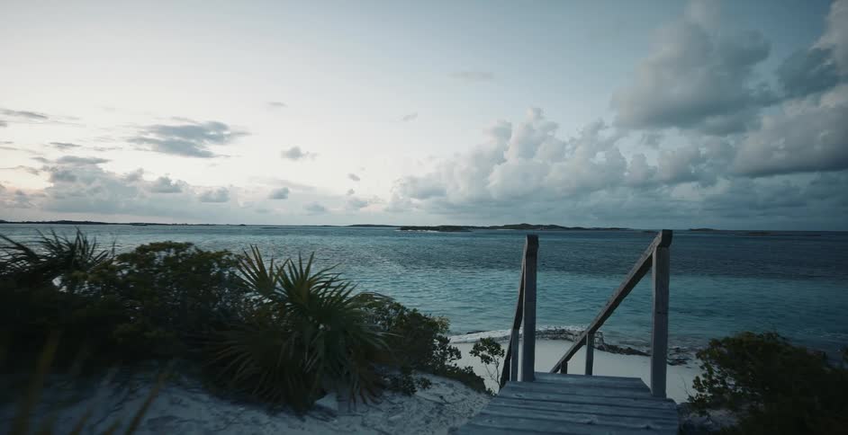 Walking along a beach access towards the water on a partly cloudy day