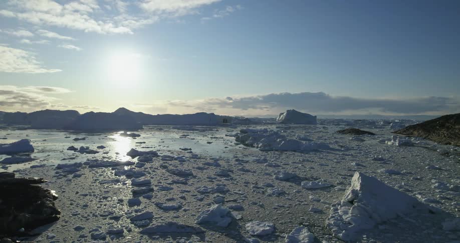 Panoramic view of ice floating in the ocean next to the mountains at daytime