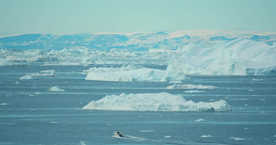 A sailboat is driving through the ocean in winter
